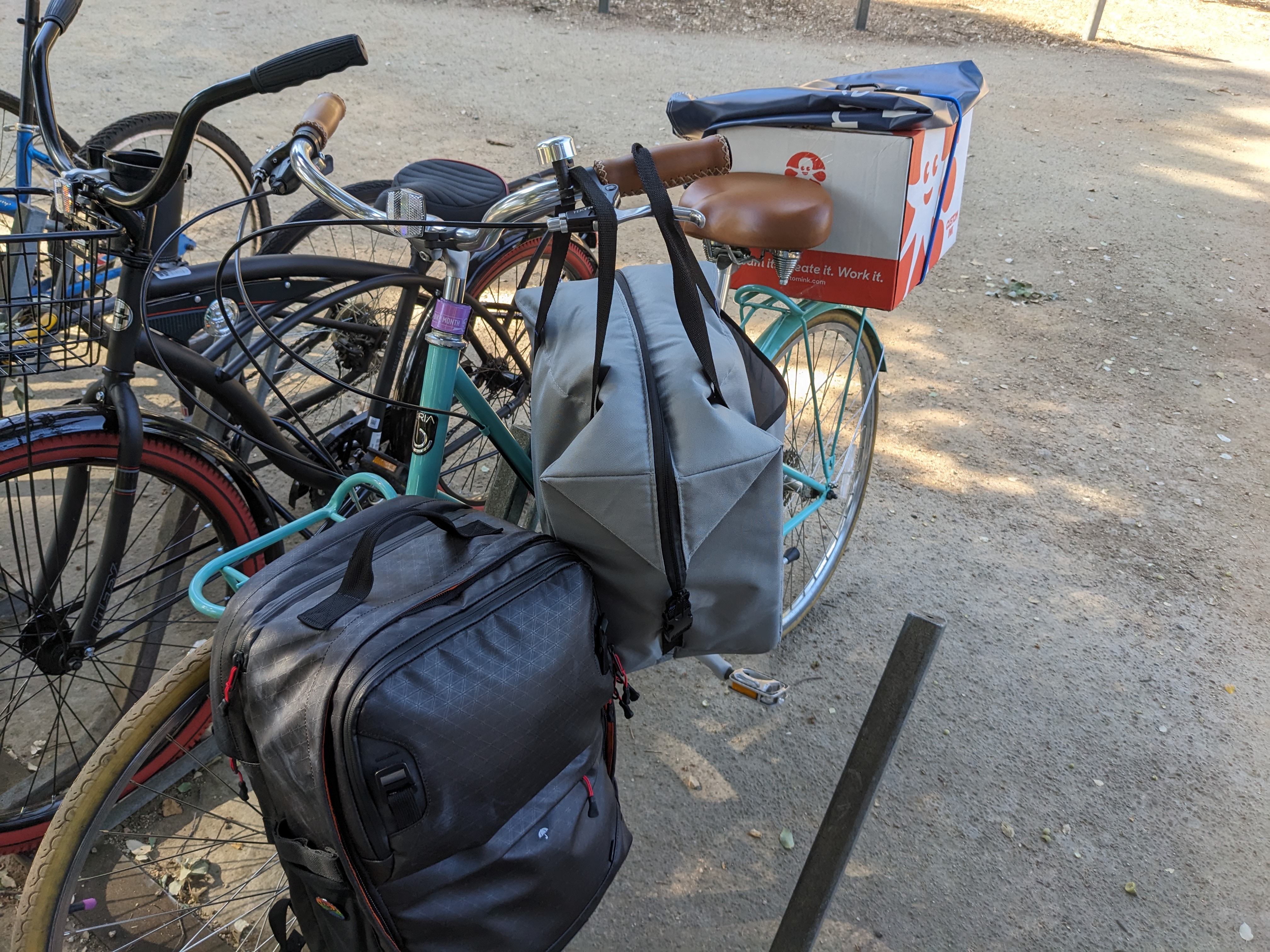 A teal bike carrying many things.